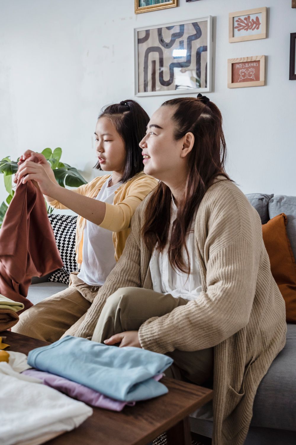 A mother and daughter folding laundry together at home